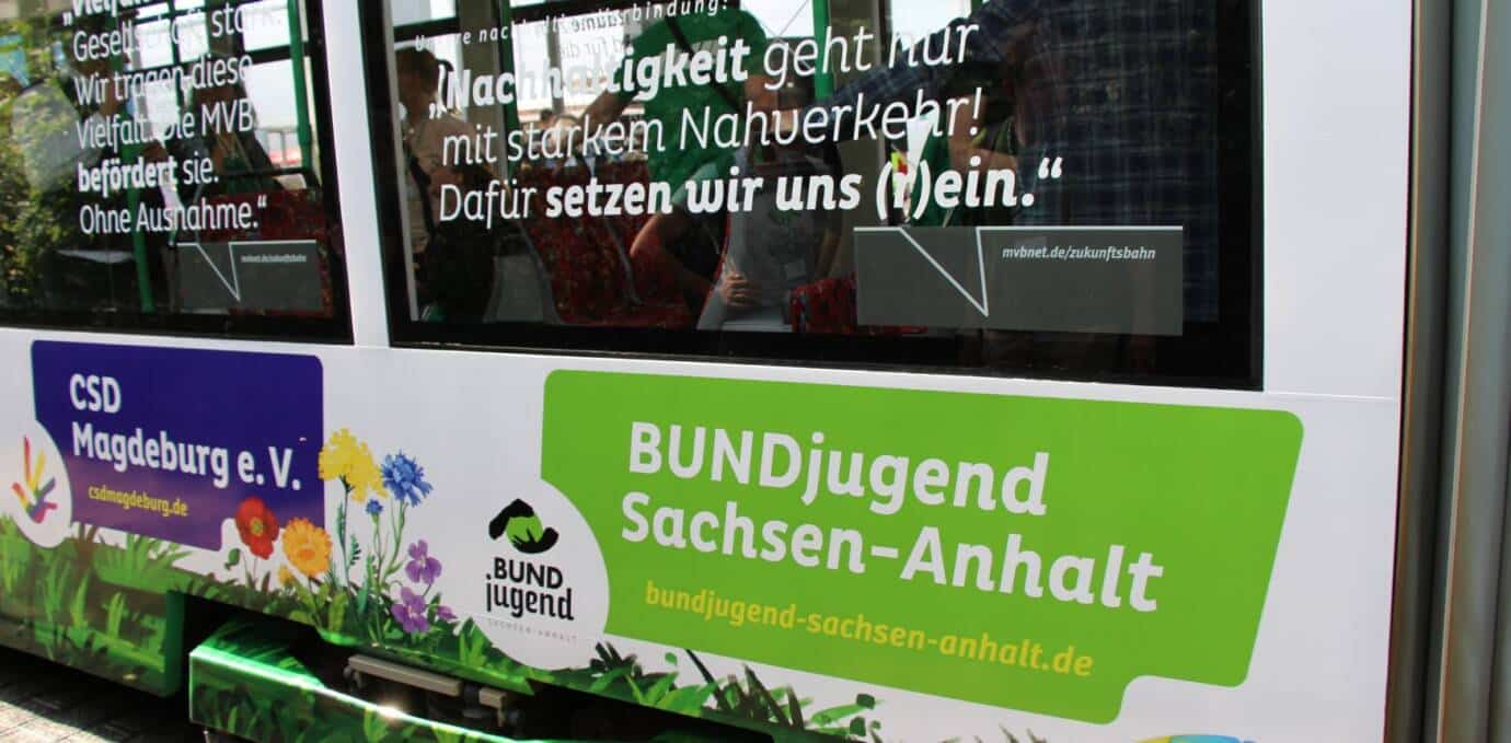 Tram mit Werbung für Nachhaltigkeit und Jugendorganisationen.