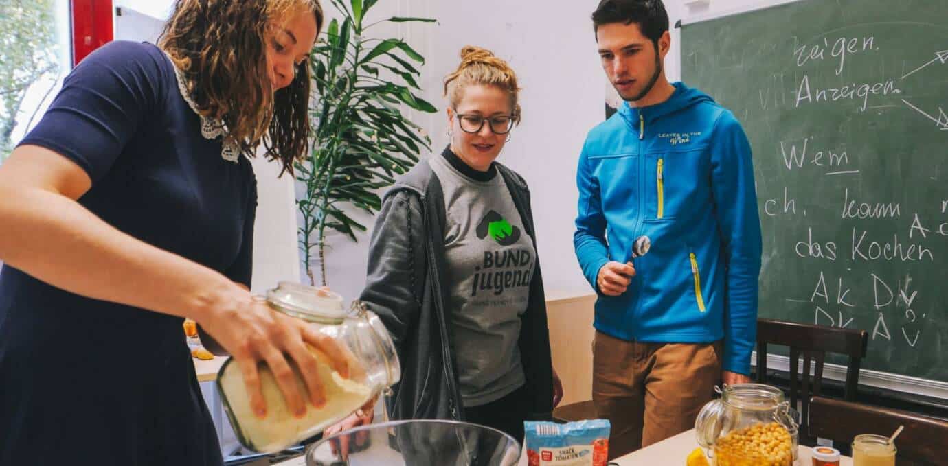 Junge Menschen beim gemeinsamen Kochen in einer Küche.