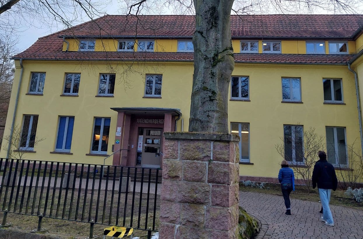 Gelbes Gebäude mit Jugendlichen davor