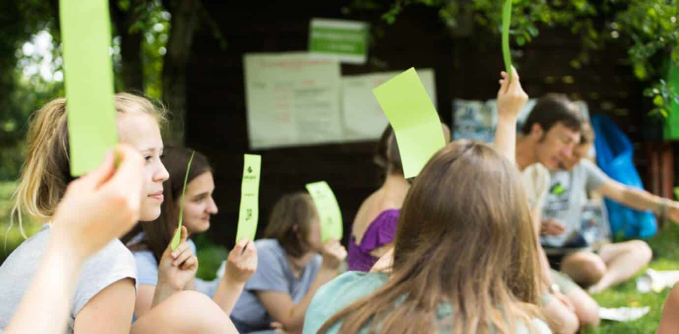 Jugendliche halten grüne Karten im Unterricht hoch.