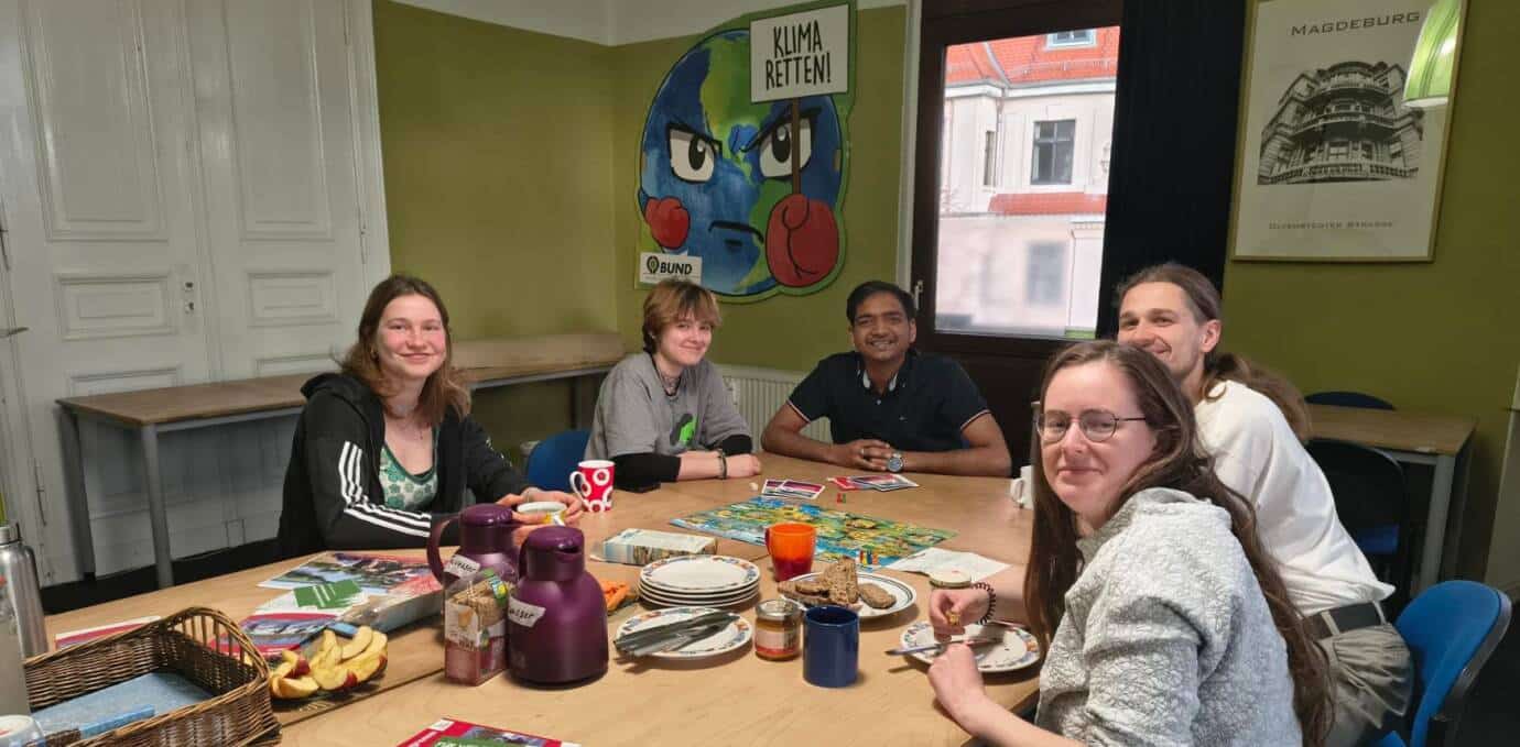 Gruppe am Tisch mit Frühstück und Brettspiel